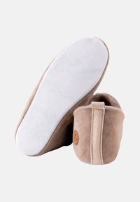 Beige Wildlederschlappen mit einer weichen weißen Sohle, ausgestattet mit einem Rückenteil für einfaches Anziehen und einem kleinen Logo an der Seite.