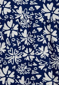 Jūras spēku audums ar baltām ziedu un sirdsmotīvām; iekļauj nelīdzenas formas un plankumainu tekstūru, ar krokām uz jostas.