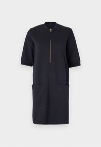 Marineblaues Jersey-Kleid mit kurzem Reißverschluss an der Vorderseite, Stehkragen und zwei großen Vordertaschen. Kurze Ärmel mit Bunddetails.