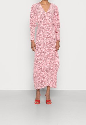 Langkleid mit rot-weißem Muster, V-Ausschnitt, langen Puffärmeln und asymmetrischem Saum. Modell trägt rote Sandalen mit Absatz.