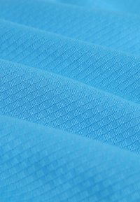 Material texturat de culoare albastră cu o ușoară strălucire, având un model geometric de mici diamante, care evidențiază valuri și pliuri.