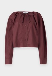 Burgundy cropped blouse in lightweight fabric, featuring a tie neckline, long sleeves, and a front button closure. Smooth texture with minimal detailing.