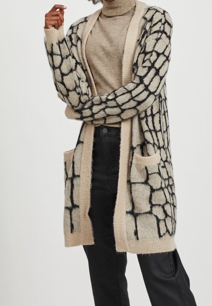 Stickad lång cardigan i beige med svart rutmönster, med öppen front, långa ärmar och två framfickor. Mjuk textur.