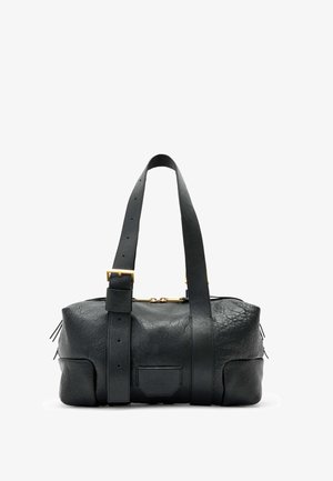 Μαύρη δερμάτινη τσάντα χειρός με υφή, διαθέτει χρυσές λεπτομέρειες σε στοιχεία, ρυθμιζόμενους ιμάντες και πλαϊκούς φερμουάρ για επιπλέον λεπτομέρεια.