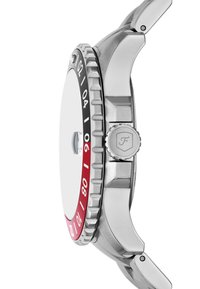 Montre en acier inoxydable avec un cadran blanc rond, lunette rouge et noire, couronne texturée et accents métalliques. Design de boîtier ergonomique remarquable.
