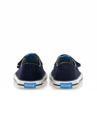 Zapatillas de lona azul marino con suelas de goma blancas, que presentan un logo azul, diseño de caña baja y correa de gancho y bucle. Textura suave.