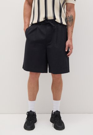 Black, knee-length shorts made of a lightweight fabric with an elastic waistband and drawstring. Features side pockets and clean hems.