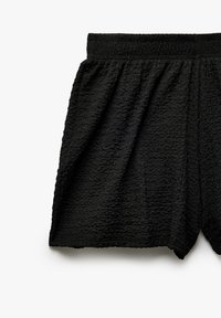 Zwarte shorts van textuurstof met een elastische tailleband, met een losse pasvorm en een subtiel golvend ontwerp overal.