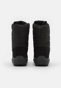 Zwarte waterdichte laarzen met een bovenwerk van gequilt stof, faux fur voering en gestructureerde rubberen zolen voor grip. Ronde neus en hoogte tot halverwege het been.
