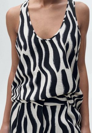 Black and white sleeveless top featuring a zebra stripe pattern, made of a smooth, lightweight fabric with a deep neckline and loose fit.
