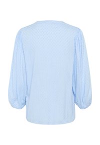 Blouse bleu clair à manches bouffantes, arborant un design à pois texturé et un col rond, faite d'un tissu doux et léger.
