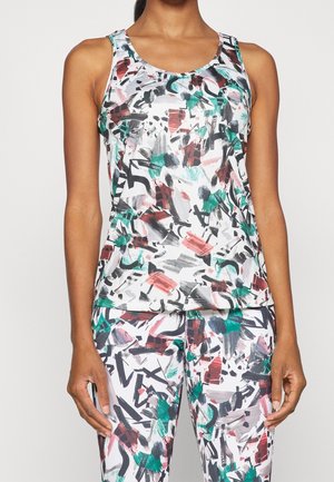 Femme portant un débardeur et un legging avec un motif abstrait de coups de pinceau noirs, verts, rouges et gris sur fond blanc.