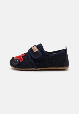 Navy blue children's shoe with a soft fabric upper, adjustable strap, and colorful truck design on the toe. Textured rubber sole.