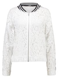 Bílá krajková bomber bunda se zipem vpředu, černobílým pruhovaným límcem, elastickým pasem a květinovým vzorem. Dlouhé rukávy.