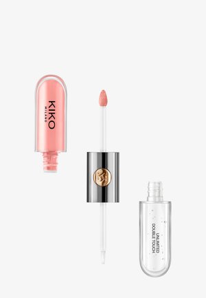 Gloss à lèvres en deux parties avec une teinte pêche et un gel transparent, doté d'un applicateur double embout et d'un capuchon argenté avec un logo doré.