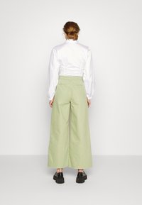ALIGNE CONNIE WIDE - Calças de ganga à boca de sino - cucumber