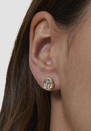 Runder Ohrstecker aus Goldmetall mit einem Cluster aus klaren und hellrosa Steinen, dargestellt auf der Haut eines Ohrs. Glatte Textur.