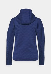 Mörkblå sweatshirt med ett texturerat triangulärt mönster, med en åtsittande huva och långa ärmar, visad bakifrån.