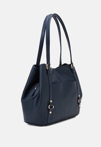 Námořnická kožená kabelka s dvojitými uchy, texturovaným povrchem, zlatými kovovými doplňky a kapsou na zip po boku pro zvýšení funkčnosti.