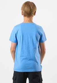 Ljusblå kortärmad bomulls t-shirt med rund halsringning. Slät textur och enkel design, sedd bakifrån. Inga mönster eller detaljer.