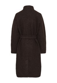 Túnica de un marrón oscuro, texturizada, con un cuello alto y una cintura ceñida. Presenta un corte holgado y aberturas laterales para facilitar el movimiento.