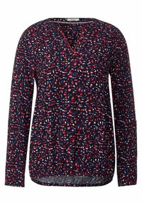 Blouse à manches longues avec un col en V, présentant un motif dans des tons de bleu marine, rouge et blanc. Fabriquée en tissu lisse avec une texture subtile.