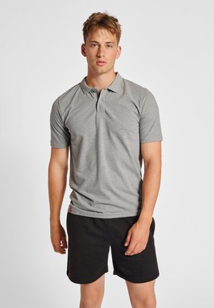 Graues kurzärmliges Polohemd mit Kragen, das eine einfarbige Textur und eine geknöpfte Leiste aufweist. Kombiniert mit schwarzen Shorts.