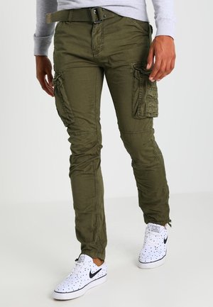 Olijfgroene cargobroek met meerdere zijzakken, taps toelopende pasvorm en van katoen. Gecombineerd met witte sneakers met zwarte accenten.