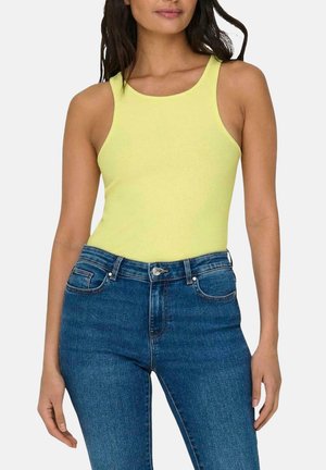 Top sin mangas amarillo de canalé con escote redondo, combinado con pantalones vaqueros de denim azul de tiro alto con puños, que presentan bolsillos delanteros y cierre de botón.