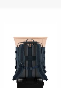 Batoh s světle růžovým víkem a námořnickými popruhy, s pevným tvarem, polstrovaným zadním dílem a nastavitelnými popruhy pro pohodlí.