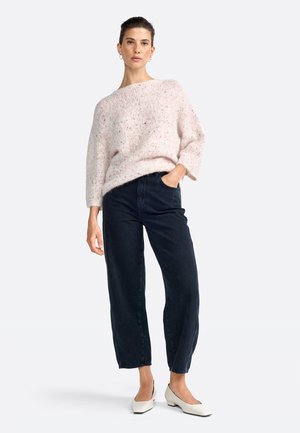 Maglione rosa chiaro in peluche con scollo ampio, abbinato a jeans a vita alta blu navy e scarpe con tacco a blocco beige.