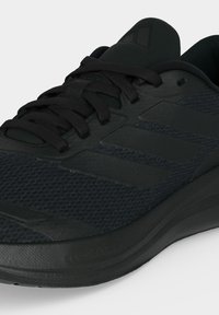 Черен спортен обувка Adidas с горна част от мрежа, три ленти на страната и връзки, показан от близък преден ъгъл.