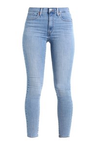 Jeans ajustados de color azul claro hechos de denim. De talle alto con un diseño clásico de cinco bolsillos y un leve desvanecimiento a lo largo de los muslos.