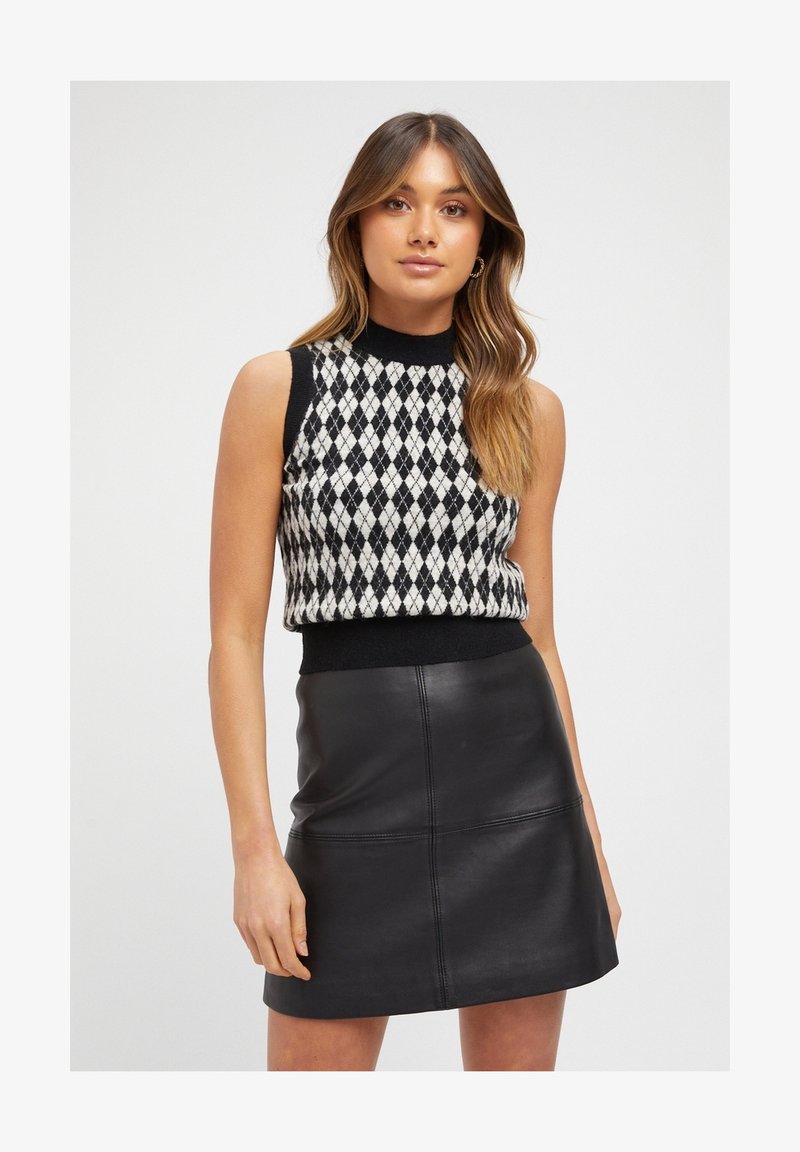 Black and white diamond-patterned knitted sleeveless top with a round neckline, paired with a fitted black leather mini skirt.