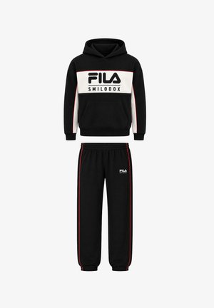 To børn iført matchende sorte FILA hættetrøjer og bukser med hvide sneakers, står side om side, hvor det ene barn lægger armen på den andens skulder.