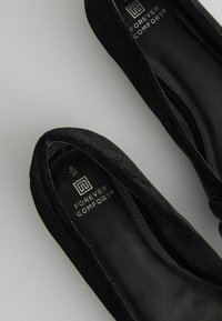 Svarta mockaskor med rund tå och en l�ätt öppning fram. Mjuk inredning och märkesinlägg med "Forever Comfort"-logotyp.