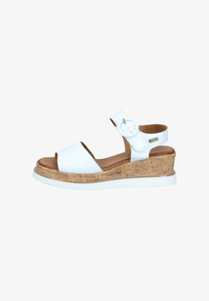 White wedge sandal with cork sole, open toe, ankle strap featuring a round buckle, and a brown cushioned footbed.
