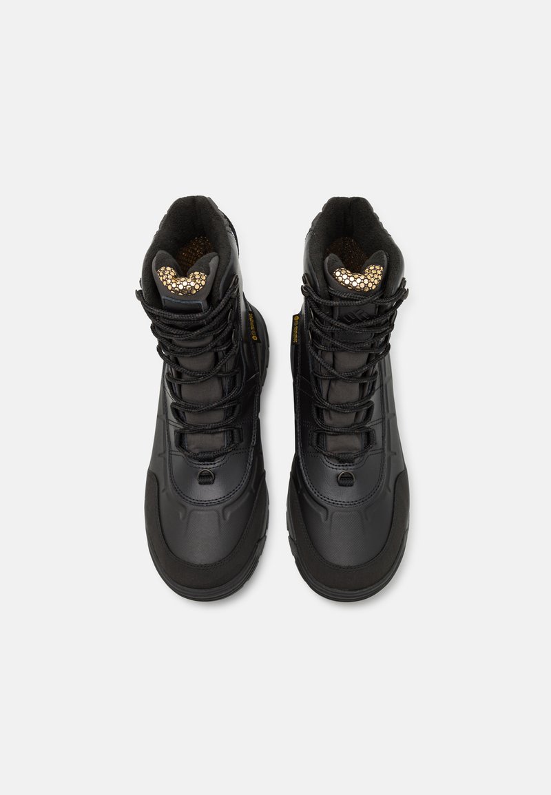 Botas impermeables negras con un diseño elegante, que cuentan con suelas de goma, parte superior texturizada y plantillas con acentos dorados. Aseguradas con cierres ajustables.