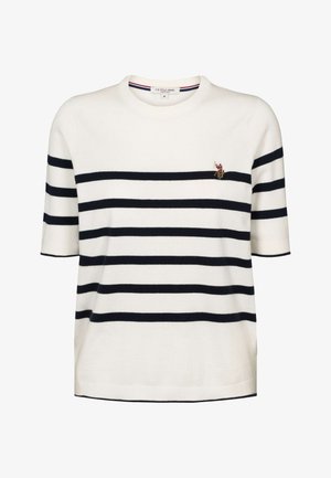 Bijeli džemper s kratkim rukavima s mornarskoplavim vodoravnim prugama. Ima mali vezeni amblem na prsima i okrugli izrez. Mekana tekstura.