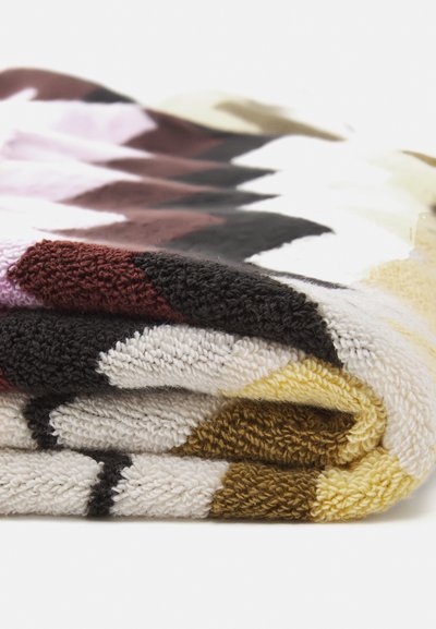 Πολύχρωμο φλις κουβέρτα με γεωμετρικό σχέδιο σε αποχρώσεις του μωβ, καφέ, μαύρου, άσπρου και κίτρινου, με μαλακή, υφή.