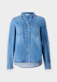 Chemise en denim bleu clair à manches longues, boutonnée sur le devant, avec deux poches poitrine et un col pointu, présentée sur fond blanc.
