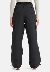 Black snow pants with a relaxed fit, featuring cargo pockets, adjustable cuffs, and a smooth texture. Logo detail on the waistband.