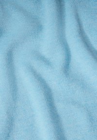 Tessuto azzurro chiaro con una texture liscia, caratterizzato da un sottile motivo a righe e onde delicate, che indica flessibilità e morbidezza.