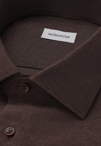 Camicia color marrone scuro con colletto e due bottoni visibili, con un'etichetta bianca che riporta la scritta "seidensticker" all'interno del colletto.