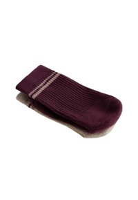 Bordové a béžové rebrované ponožky s jemnými pruhovanými akcentmi, s mäkkou textúrou a štandardným tvarom ponožiek, vystavené v stohu.