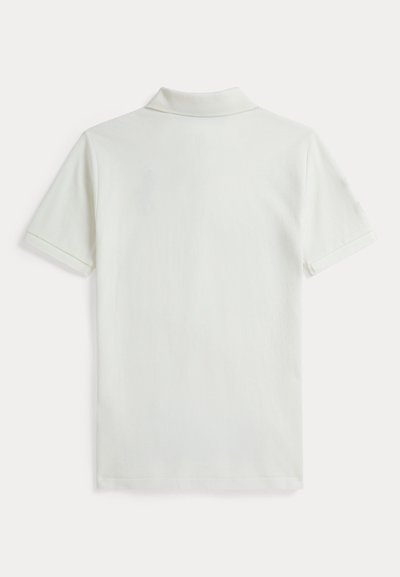 Λευκό πόλο πουκάμισο με κοντά μανίκια και γιακά που διπλώνει. Το ύφασμα έχει ομαλή υφή χωρίς ορατά μοτίβα ή σχέδια.