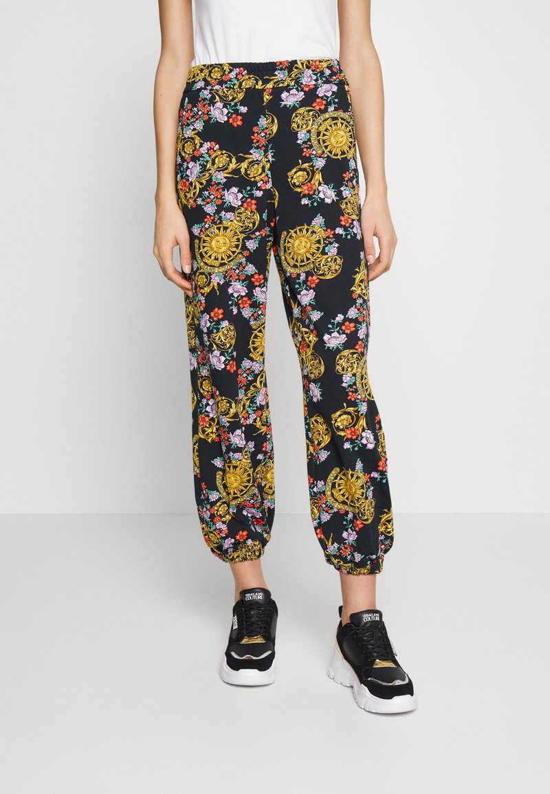 Czarne spodnie w kwiaty ze złotymi akcentami. Posiadają elastyczny pas i mankiety, z mieszanką kolorowych kwiatów i misternych wzorów.