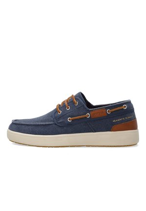 Marineblauwe casual bootsschoen met bruine lederen accenten, beige veters, witte zool en gestikte coördinaten op de hiel.