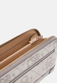 Portfel zapinany na zamek w beżowym płótnie z jasnoszarymi akcentami, z tłoczonym wzorem logo, wieloma przegródkami i złotym okuciem.