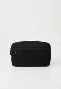 Borsa in tessuto nero con una texture liscia, chiusura a zip e tirazip rossi. Presenta una tasca frontale e un marchio impresso sul lato.